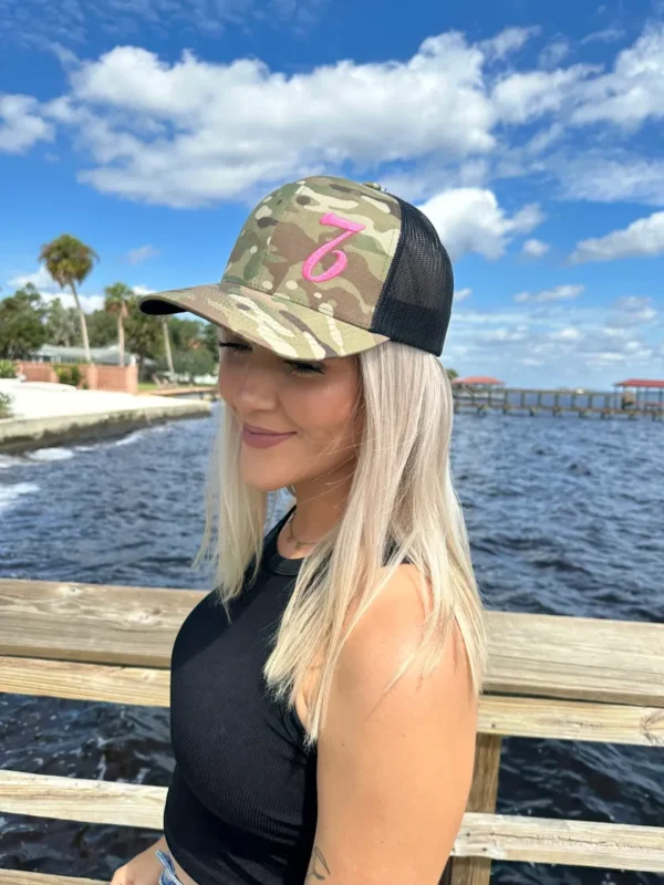 A woman wearing a hat near the water.