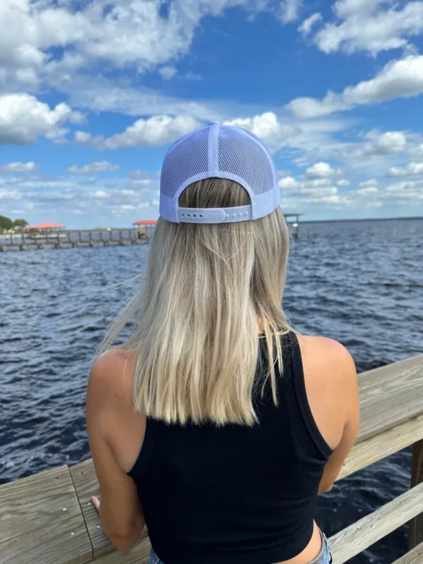 A woman with long blonde hair wearing a blue hat.