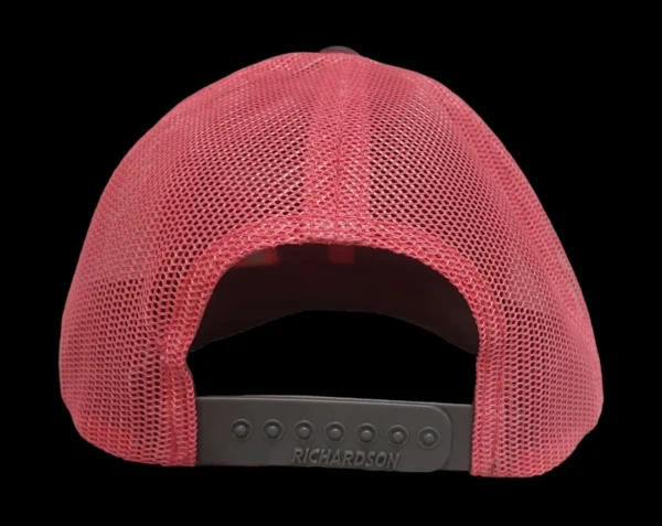 A pink hat with a black strap on top of it.