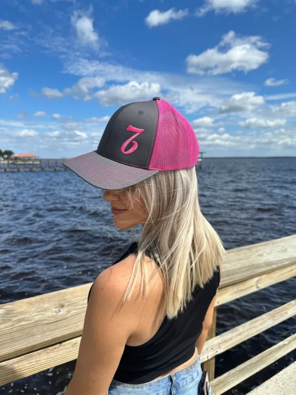 A woman wearing a hat near the water.